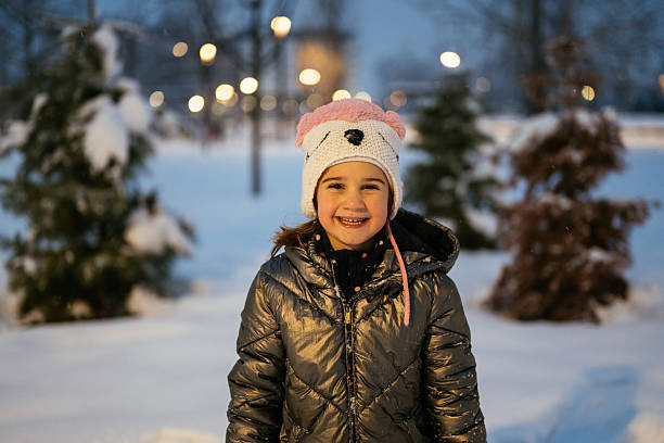 Kids enjoying winter and snow outdoors in late afternoon
