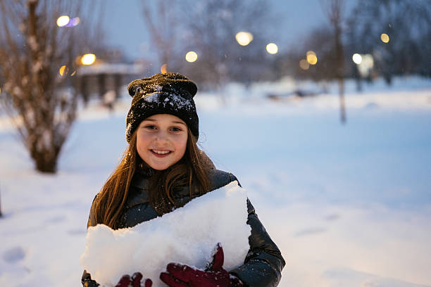 Kids enjoying winter and snow outdoors in late afternoon