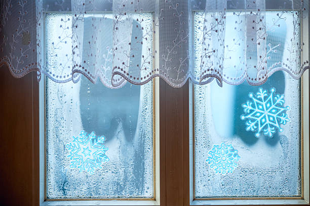 In the living room of a senior person, white curtains gently filter the sunlight through the window.