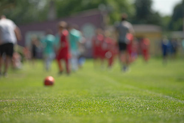 Kids playing soccer in soccer ground of a school.