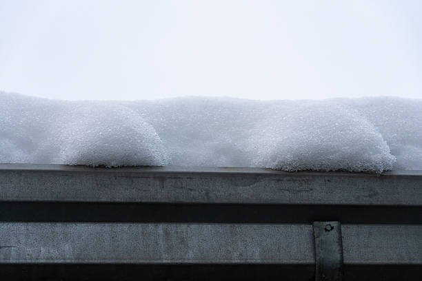 Minimalist winter background with fresh snow layer on metal roof edge. Cold weather concept, copy space, calm neutral tones, seasonal background for design and advertising