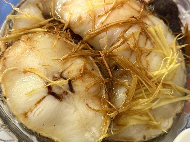 Asian flavor steamed cod fish slice over soy sauce dish