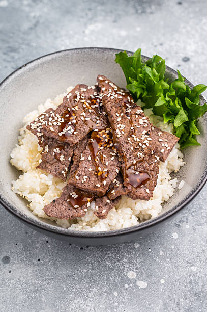 Delectable yakiniku feast, featuring a variety of marbled beef cuts and rice. A culinary journey that captures the essence of Japanese grilling traditions. grey background. top view