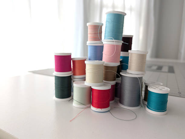 Soft focus of tangled colorful threads on bobbin from sewing machine on blurred background