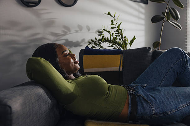istock Woman Lying Back on Sofa Enjoying Restful Moment at Home 2255407654