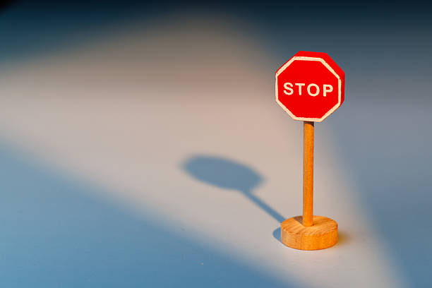 istock Wooden stop sign on a soft gradient background representing the pause needed to stop bad habits and improve overall personal health. 2255408933
