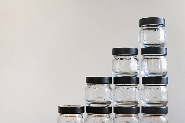 This is a photograph of a stack of reusable glass jars at home indoors.
