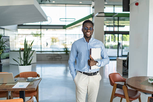 istock Professional african man smiling holding laptop in modern office 2255411359