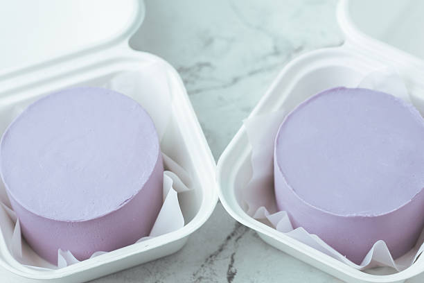 Two violet bento cakes without decoration in a gift boxes with a blank top for your own text. Mockup cake for advertising