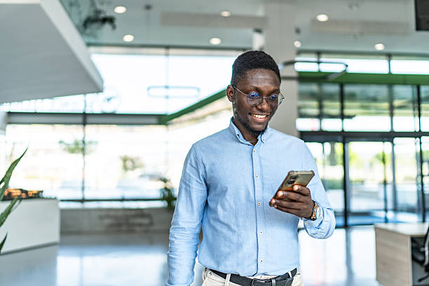 istock Young black businessman checking smartphone in modern office 2255412294