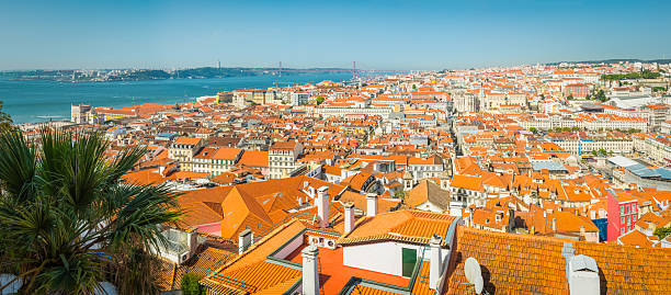 Panoramic aerial view over the landmarks and terracotta rooftops of Baixa and Praca do Comercio to the blue waters of the Tagus in the heart of Lisbon, Portugal’s vibrant capital city.