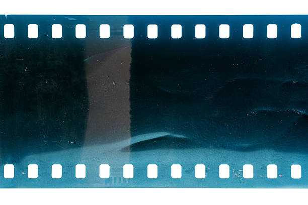 Dusty and grungy 35mm film texture or surface. Perforated scratched camera film isolated on white background.