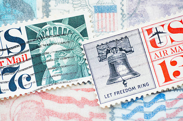 Close-up of a United States postage stamp featuring the Statue of Liberty and the Liberty Bell of Philadelphia. Concept of freedom, democracy, and national symbols.