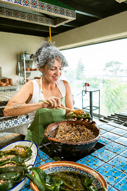 Tourist stuffing chiles poblanos to make chiles en nogada in cooking class