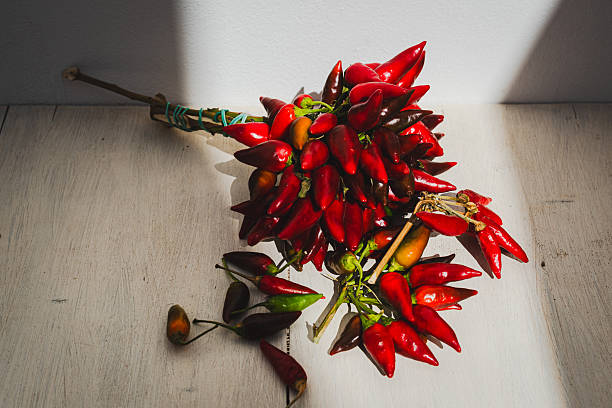 A bunch of red chili peppers between the bright southern sun and its white walls.