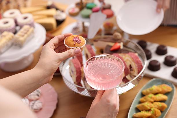 People with drinks and delicious desserts at buffet table, selective focus