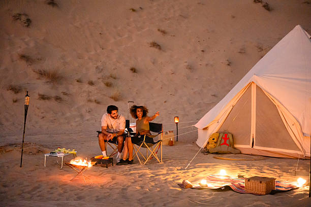 istock Couple glamping on desert sand dunes at night 2255429538