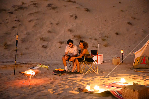 istock Couple enjoying desert glamping with bonfire and grilled corn 2255429543