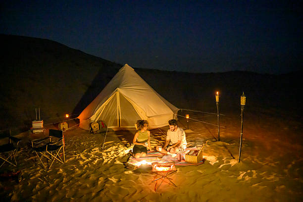 istock Couple enjoying glamping in desert at night with campfire 2255430084