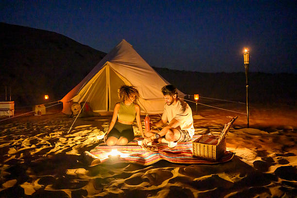 istock Couple enjoying glamping picnic at night in desert 2255430090