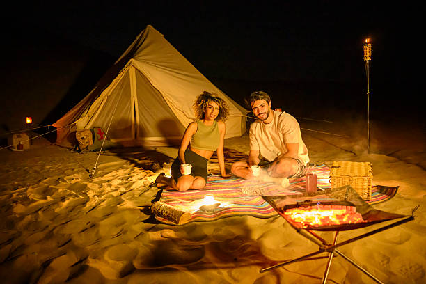 istock Young couple enjoying desert camping glamping with campfire at night 2255430121