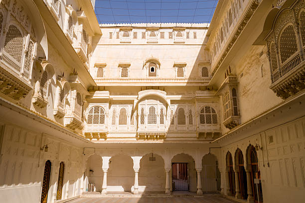 People walking in the busy sardar market a historic entrance gate with bright blue sky at day in Jodhpur, Rajasthan