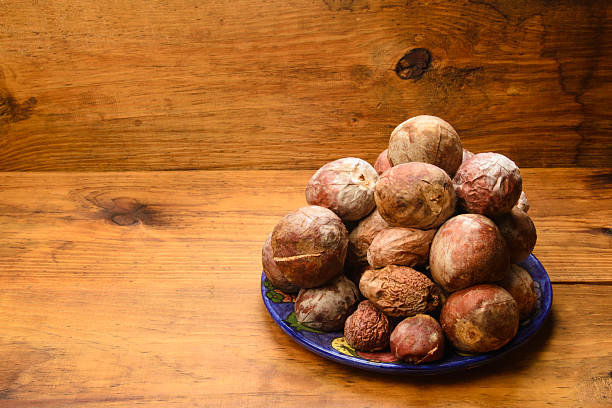 Pile of avocado seeds made in studio with strobe lights over wood material . Don't throw away avocado seeds, as they have many beneficial health properties. You can find tutorials online on how to prepare them.