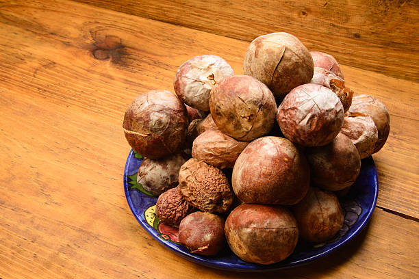 Pile of avocado seeds made in studio with strobe lights over wood material . Don't throw away avocado seeds, as they have many beneficial health properties. You can find tutorials online on how to prepare them.