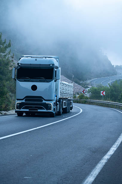 Photo of winding asphalt road in mountain range. No recognizable people are seen in frame. Shot with a full frame mirrorless camera.