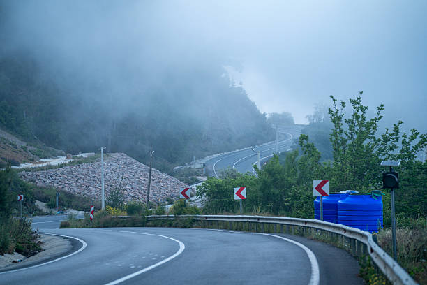 Photo of winding asphalt road in mountain range. No recognizable people are seen in frame. Shot with a full frame mirrorless camera.