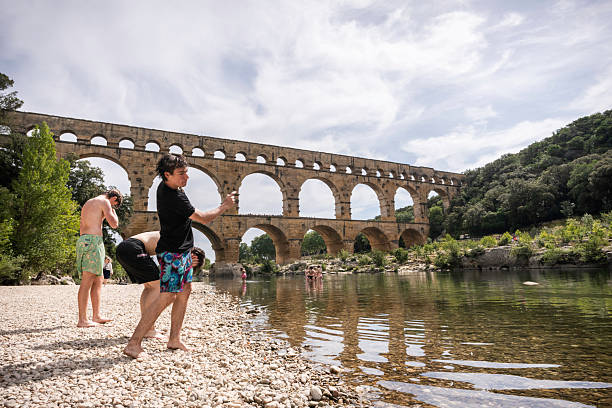 Pont du Gard, France - June 18, 2024: Tourists visit the ancient Roman aqueduct built in 1AD, which carried water 31 miles to Nimes, Provence
