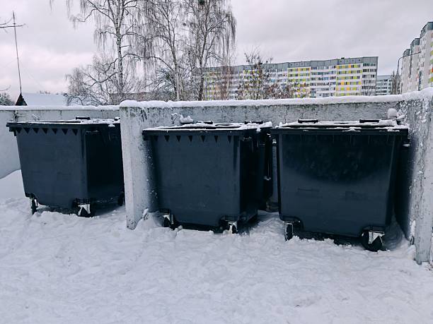 istock Snow-covered garbage bins in urban winter setting 2255435742