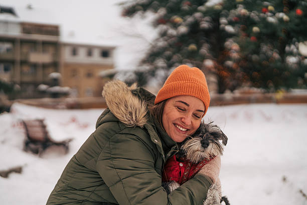 istock Woman hugging small dog finding joy in winter snow 2255436054