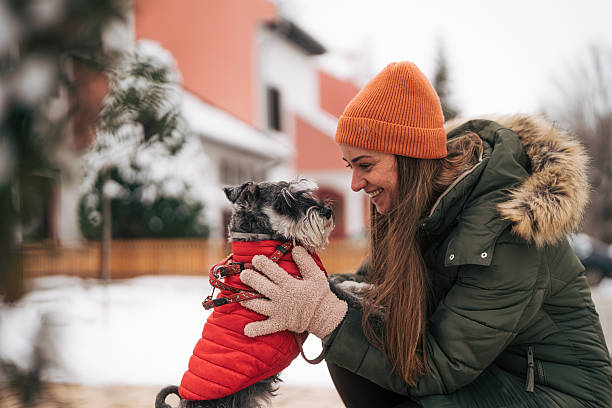 istock Young woman enjoying winter day with miniature schnauzer 2255437134
