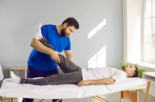 istock Physiotherapist work with patient leg after injury 2255437220
