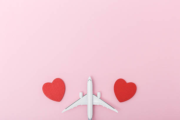 istock Airplane model positioned between two red heart shapes on a soft pink background, symbolizing love and travel, perfect for romantic themes and holiday promotions 2255440080