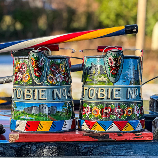 View of two ornate painted buckets on a narrow boat, UK.  There are no people in the photograph.