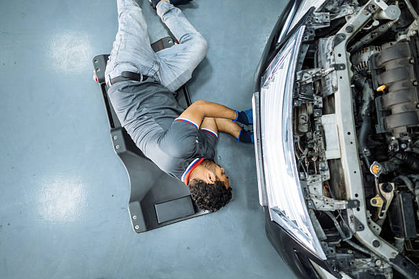 Portrait male mechanic examining car in auto repair shop.professional engineers working in auto repair car service for the maintenance and repairing the vehicles.