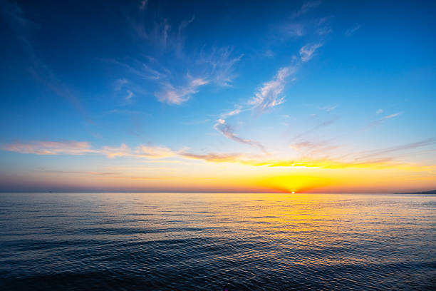 istock Sunset Over Calm Ocean With Vibrant Sky Illuminating the Horizon 2255448956