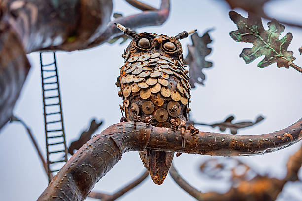 31 October 2025, Tbilisi, Georgia: Rustic steampunk owl sculpture crafted from recycled scrap metal components, sitting on a metal tree