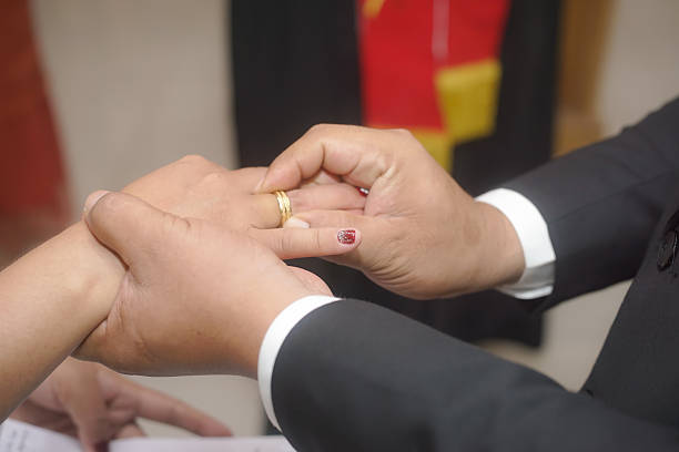 Unrecognizable bride and groom hugging on wedding day.