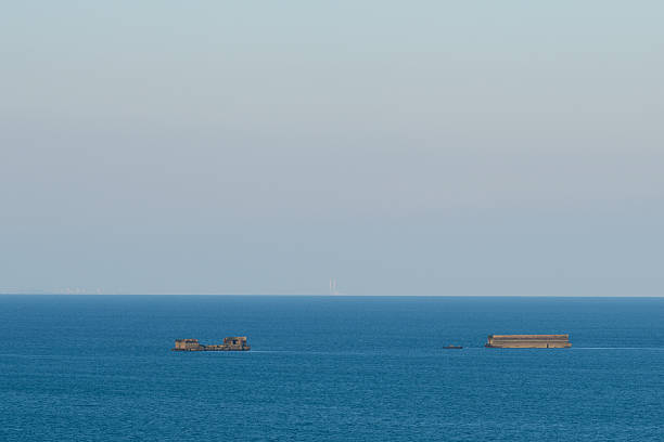 Sunrise view over the incomplete monopole transmission tower under construction in the sea.