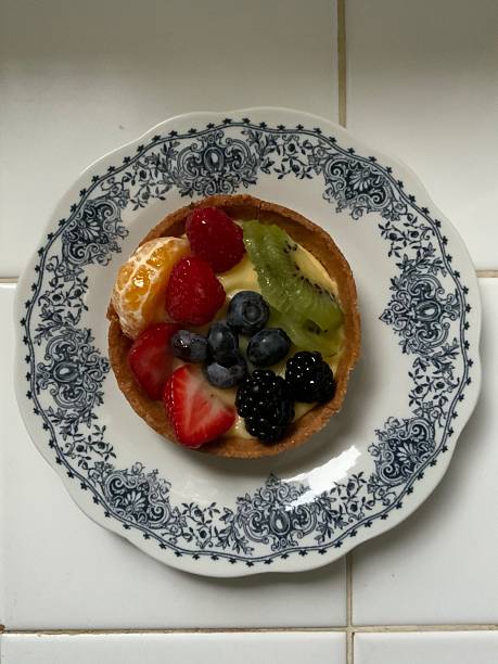 A delightful fruit tart with a buttery, flaky crust filled with creamy custard and topped with an array of fresh, vibrant fruits. Perfectly balanced between sweet and tangy, making it irresistible