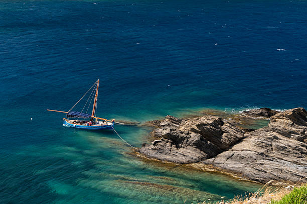 Port lligat, Spain - July 5, 2024: Distant view of tourists relaxing on a sailboat in the Mediterranean Sea in the Cap de Creus Natural Park along the rocky Costa Brava, the easternmost point of Catalonia Spain near Cadaques, Girona
