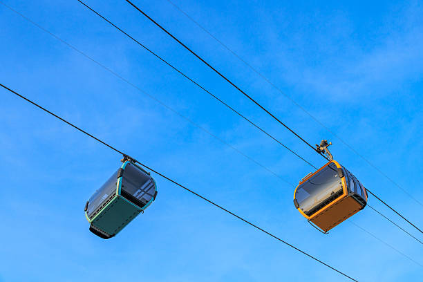 Cable car -  ski lift at sunny  ski resorts.   Blue clear sky in background.