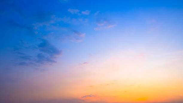 istock Beautiful sunset sky with orange, yellow and blue gradient. Twilight sky background with soft clouds. Natural dramatic sky backdrop 2255484364