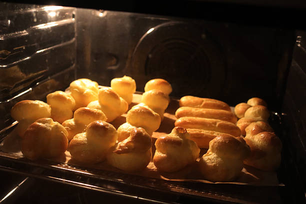 Close-up of many Choux pastries in hot oven on selective focus