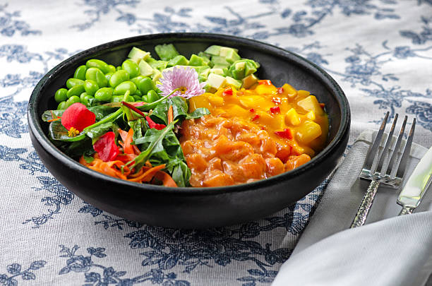 Delicious salmon and avocado poke bowl garnished with sesame seeds and seaweed, stylized food photography, vibrant color composition