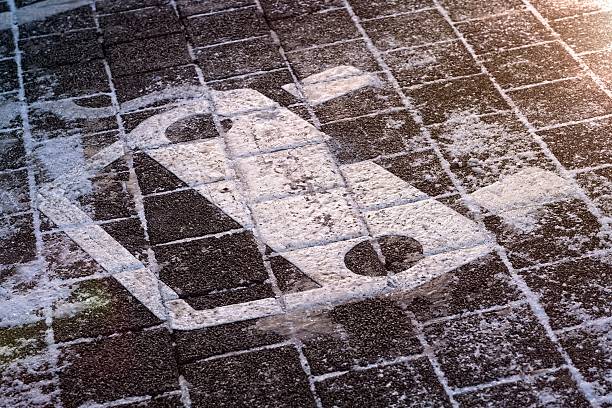 A muscular, funny figure of an athlete is drawn in chalk on the gray asphalt