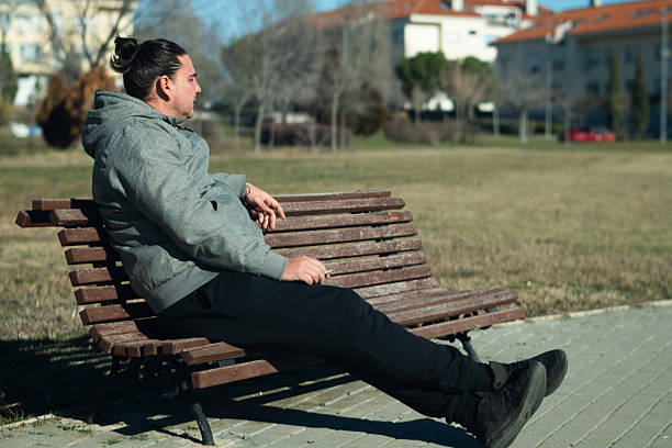 istock Man relaxing on park bench smoking a cigarette 2255506998